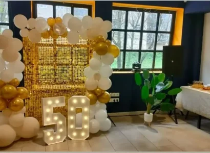 Salón privado en restaurante con mesas preparadas para evento, decoración elegante y pantalla plana, ideal para celebraciones en Coslada.