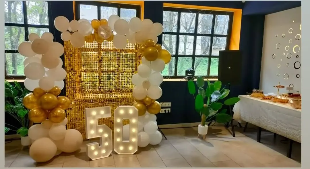 Salón privado en restaurante con mesas preparadas para evento, decoración elegante y pantalla plana, ideal para celebraciones en Coslada.